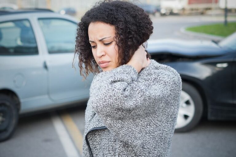 This image is of a woman holding her neck after a car accident, concept of a n Atlanta car accident claim