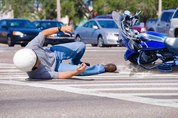 Concept of Perry motorcycle accident lawyer, biker falling off motorcycle in traffic